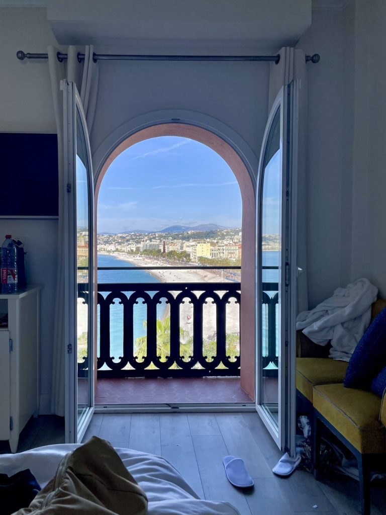 Hotel Suisse Nice Review: Iconic Sea Views on the French Riviera 10 Mediterranean Sea and Nice coastline framed by arched balcony from a room at Hôtel Suisse Nice.