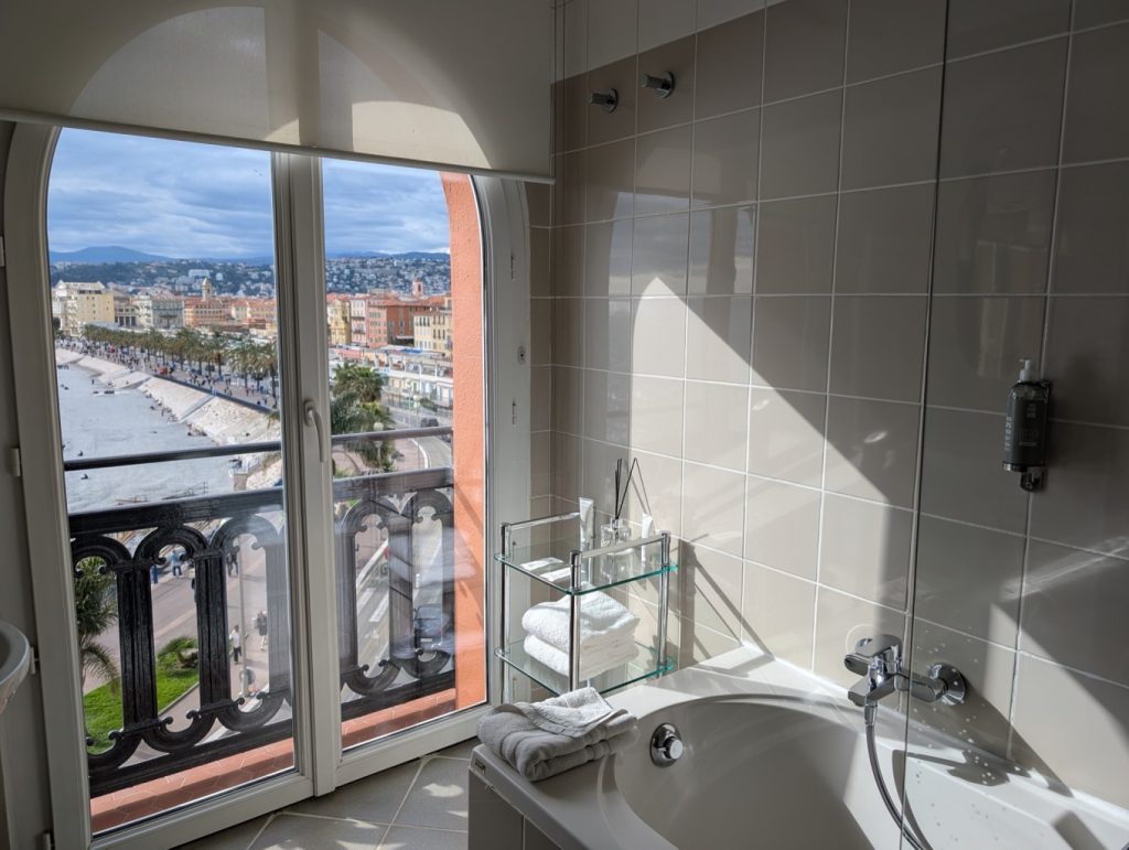 Hotel Suisse Nice Review: Iconic Sea Views on the French Riviera 7 Bathroom at Hôtel Suisse Nice with bathtub and balcony overlooking Old Town Nice and the beach.