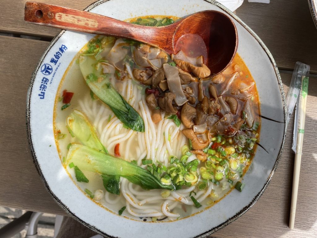 Wuxi Nianhua Bay: A Peaceful Zen Town Blending Tang-Song Architecture and Jiangnan Charm 12 A bowl of rice noodles with vegetables and mushrooms at Wuxi Nianhua Bay.