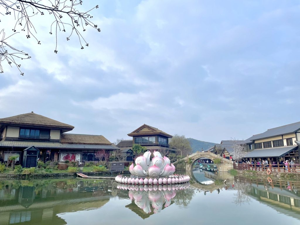 Wuxi Nianhua Bay: A Peaceful Zen Town Blending Tang-Song Architecture and Jiangnan Charm 6 Reflection of ancient buildings and lotus sculpture on the canal.