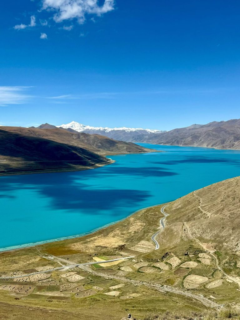 Sweeping view of Yamdrok Yumtso Lake with snow mountains in the distance