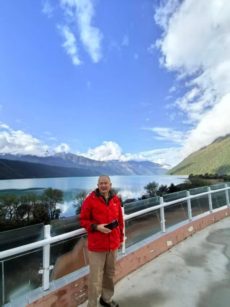 Panoramic view of Yarlung Tsangpo Grand Canyon valley in Nyingchi Tibet, with green mountains and low-hanging clouds.