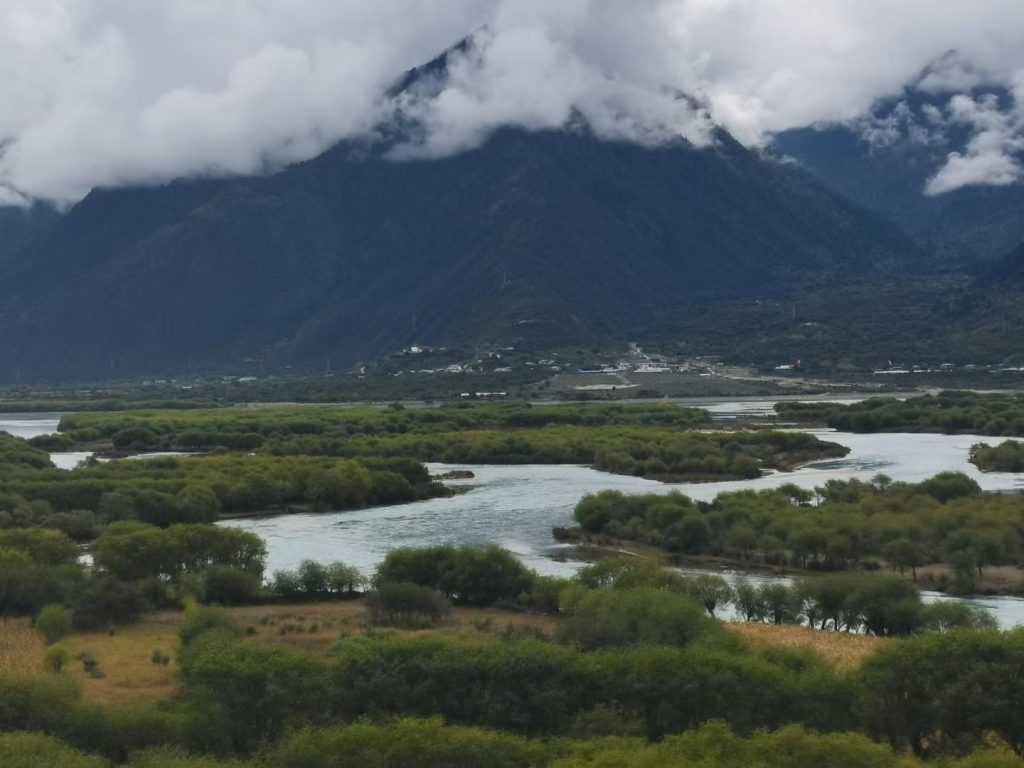 Calm river reflection of mountains and clouds in Yarlung Tsangpo Grand Canyon Tibet.