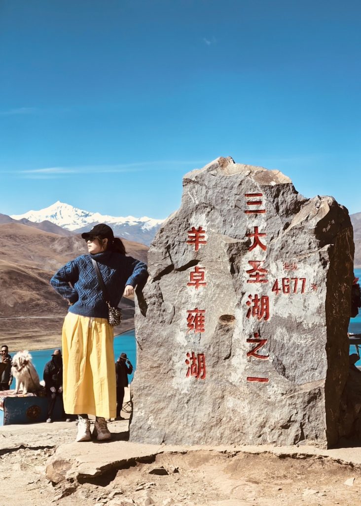 How to Plan a Trip to Tibet? 9 Standing beside the stone tablet marking Yamdrok Lake, one of Tibet’s three sacred lakes