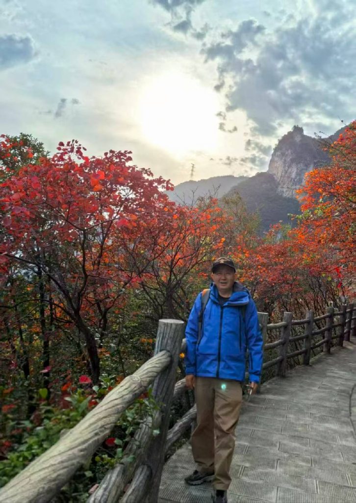 Autumn at Goddess Peak: A Family Journey Through the Three Gorges 8 Visitor walking along wooden trail with red leaves at Goddess Peak.