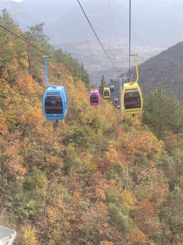 Autumn at Goddess Peak: A Family Journey Through the Three Gorges 12 Colorful cable cars gliding over autumn forest at Goddess Peak.