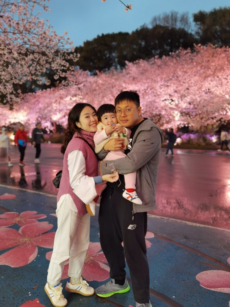Yuantouzhu Cherry Blossom Park: Discover Wuxi’s Hidden Sakura Wonderland 13 Family photo under illuminated cherry blossoms at Yuantouzhu Wuxi at night