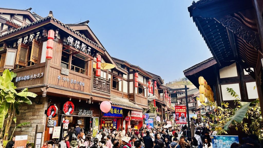 Ciqikou Ancient Town in Chongqing with traditional wooden buildings, red lanterns, and a crowded pedestrian street