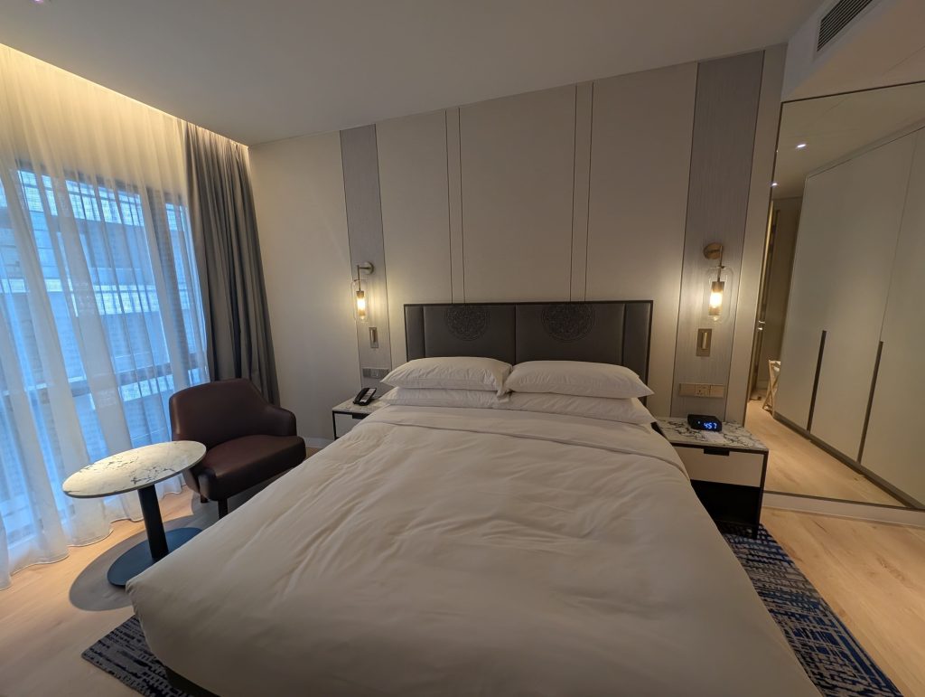 Marriott Executive Apartments Kuala Lumpur Review: Our 2-Night Family Stay 14 King bed with bedside lights and a lounge chair beside the window at Marriott Executive Apartments Kuala Lumpur.