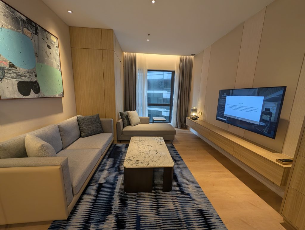 Marriott Executive Apartments Kuala Lumpur Review: Our 2-Night Family Stay 10 Living room with large sofa, chaise lounge, and abstract wall art at Marriott Executive Apartments Kuala Lumpur.