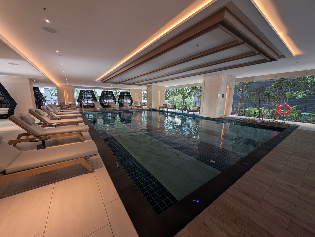 Marriott Executive Apartments Kuala Lumpur Review: Our 2-Night Family Stay 21 Semi-indoor swimming pool with loungers and greenery at Marriott Executive Apartments Kuala Lumpur.