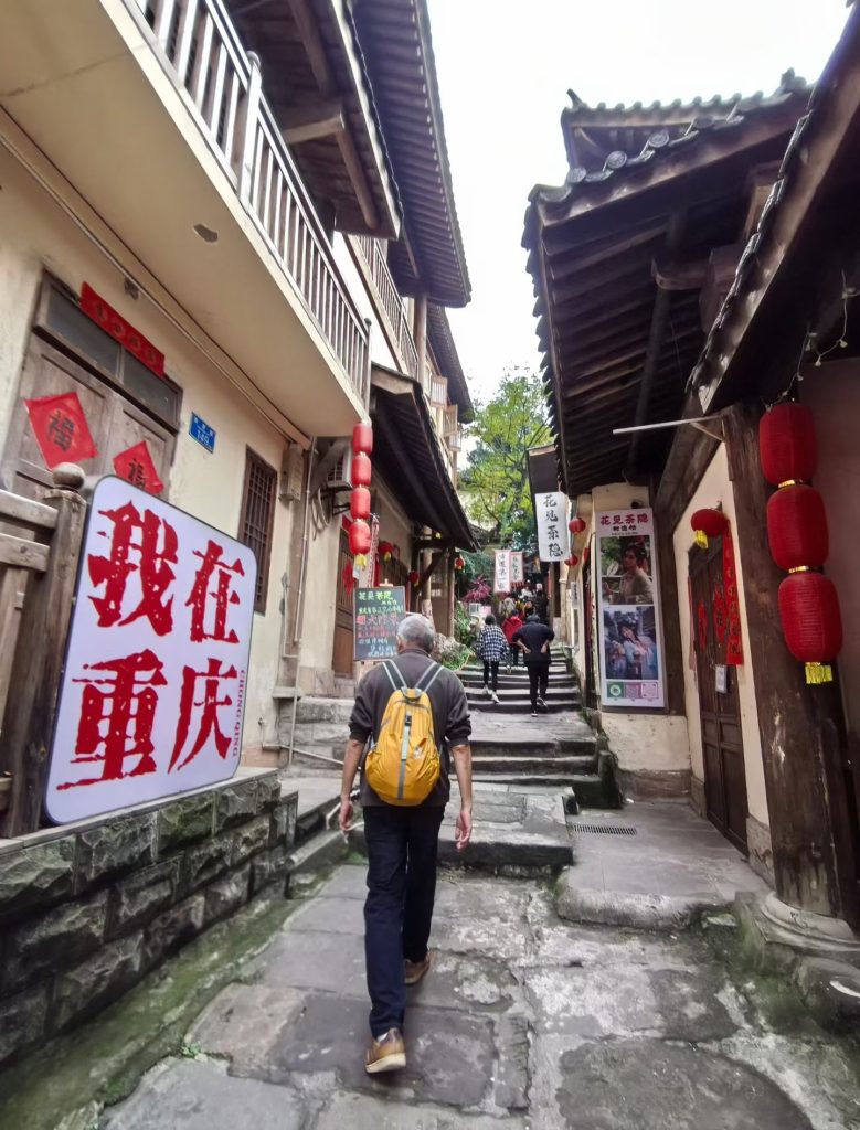 Narrow stone alley lined with wooden houses and red lanterns in a traditional Chongqing old street
