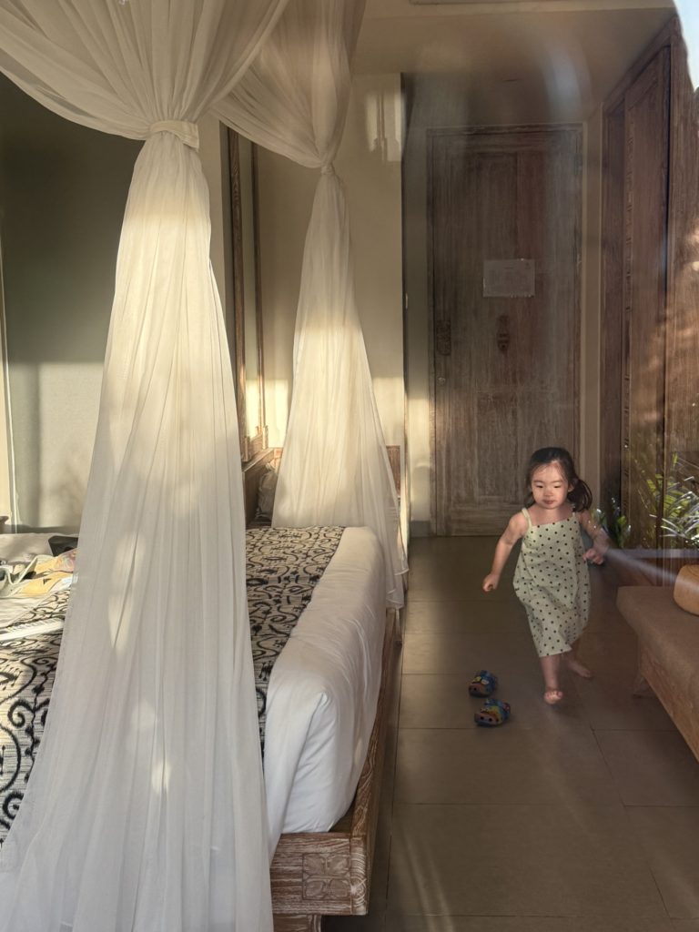 The Sun of Granary Resort and Villas Review: Family Stay Amid Ubud’s Rice Fields 13 Child playing inside villa with canopy bed and natural sunlight