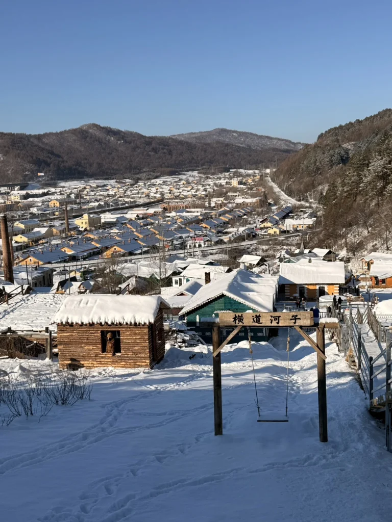 Hengdaohezi 1-Day Trip: Snowy Railway Town Near Harbin Travel Guide 19 Snowy hillside viewpoint in Hengdaohezi with a wooden swing frame overlooking the historic railway town.