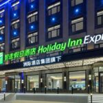 Holiday Inn Express Harbin Central Avenue entrance illuminated at night in Daoli District