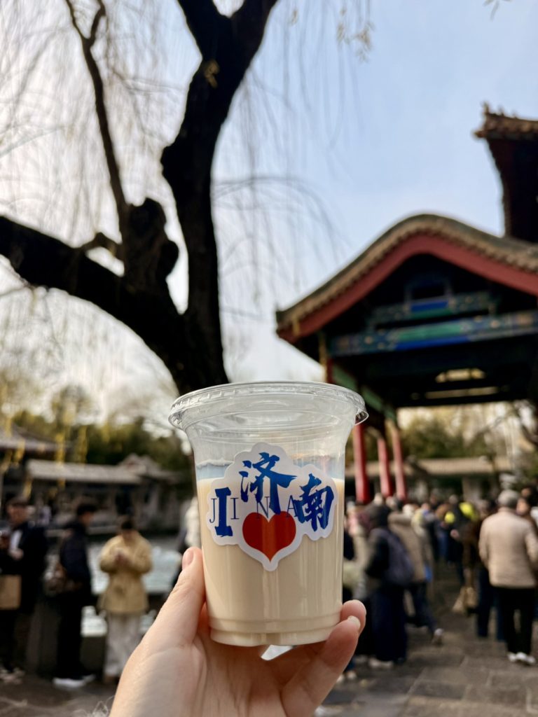 Baotu Spring Travel Guide: Visiting Jinan’s No.1 Spring 12 Milk tea by Baotu Spring with traditional pavilion and winter crowds in the background