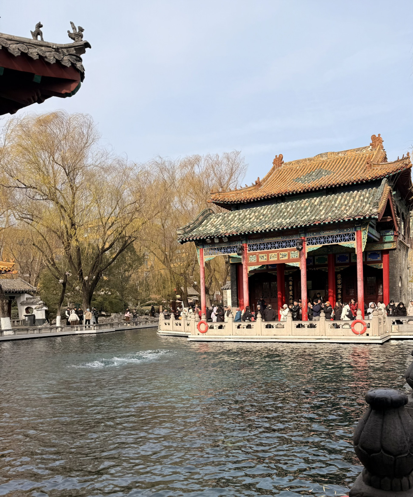 Visitors gathered around Baotu Spring pavilion and flowing spring water in Jinan