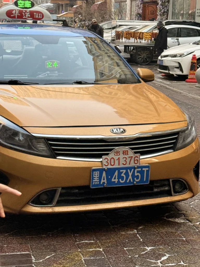 Licensed Harbin taxi with official red taxi plate and roof sign, photographed near Central Street in winter