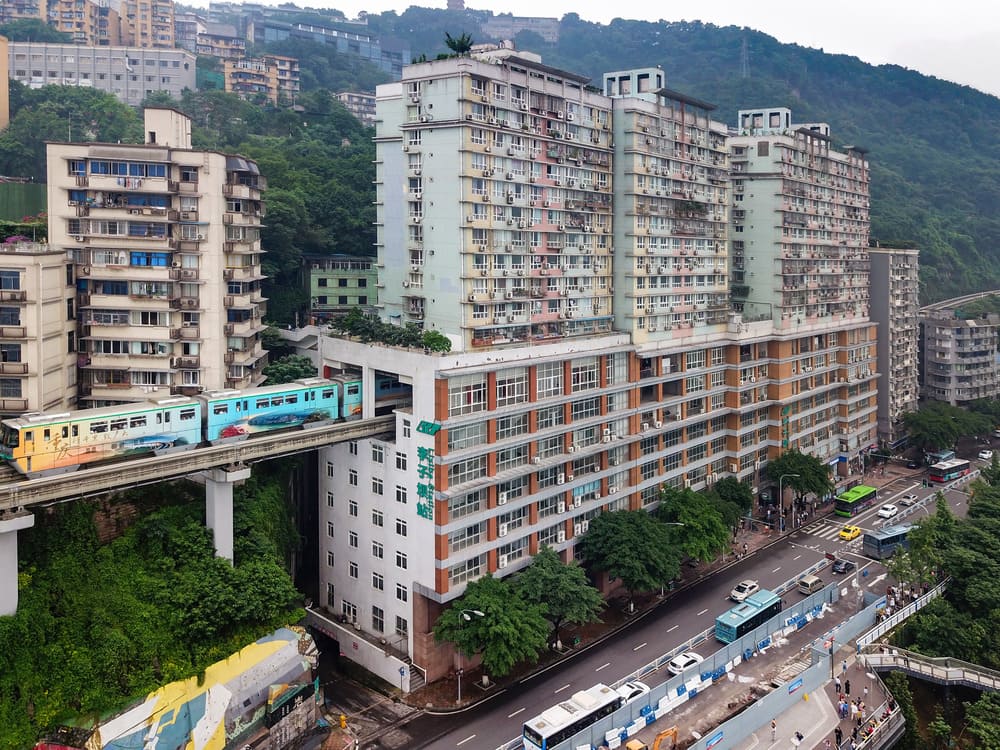 Chongqing Sightseeing Guide: Top Attractions, Travel Tips & Best Views 7 Liziba Light Rail Station in Chongqing, where a metro train passes through a residential building on an elevated track