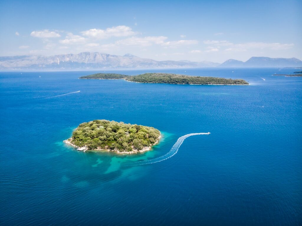 Aerial view of small green islands surrounded by clear blue ocean