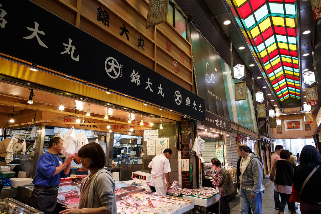 Kyoto in One Day: What to See, Do & Eat (Perfect Itinerary) 8 Shops and food stalls inside Nishiki Market in Kyoto, with vendors selling fresh seafood and local specialties