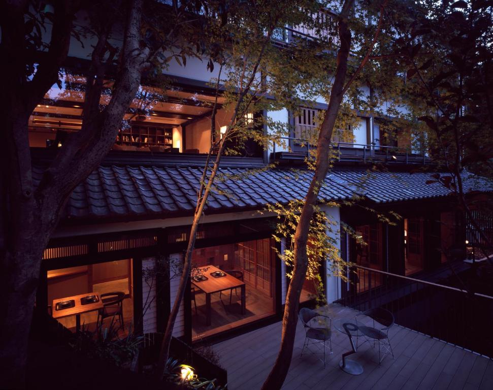 Sumiya Kihoan ryokan in Kameoka near Kyoto at dusk with traditional tiled roof, wooden architecture, and warmly lit interior overlooking a quiet terrace