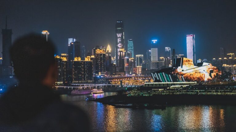 Chongqing skyline at night with illuminated skyscrapers and river reflections viewed from across the Yangtze River