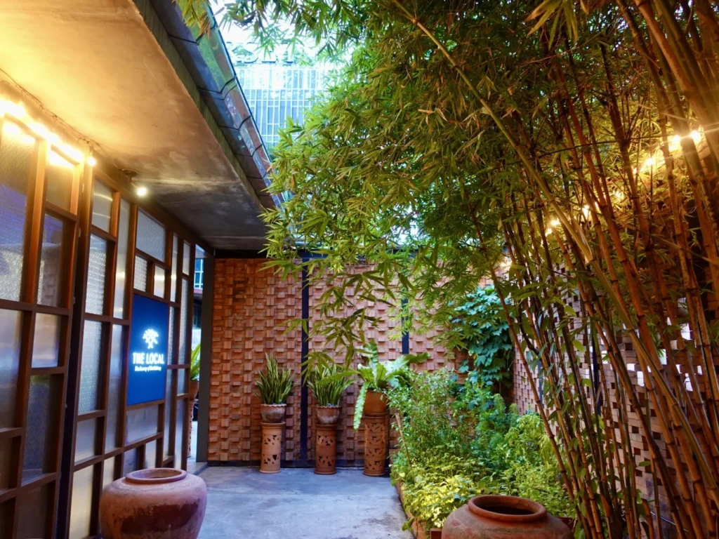 The Local Bangkok courtyard entrance with bamboo and traditional Thai décor