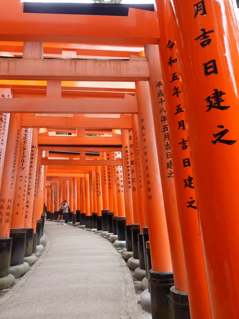 Fushimi Inari Taisha torii gate tunnel pathway Kyoto Japan with orange gates perspective