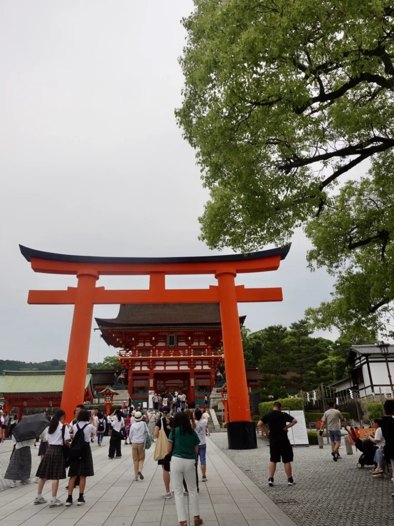 Fushimi Inari Taisha main entrance torii gate Kyoto with shrine building and visitors