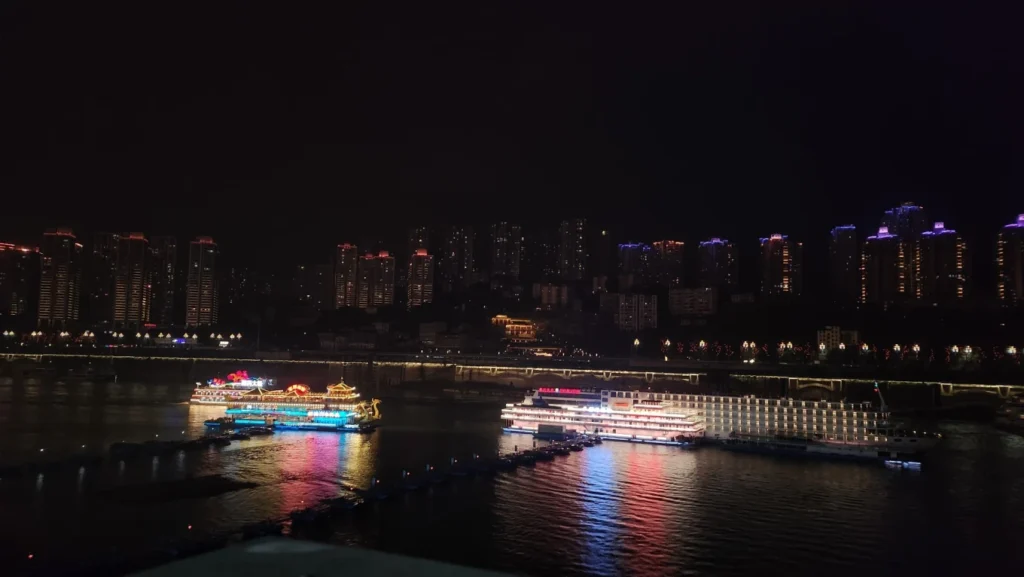 Chongqing Yangtze River night cruise with illuminated boats and city skyline reflecting on the water