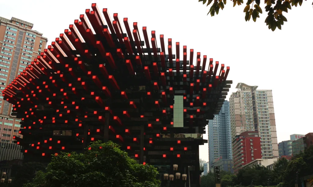 Side view of Chongqing Art Gallery with red beams against Chongqing city skyline