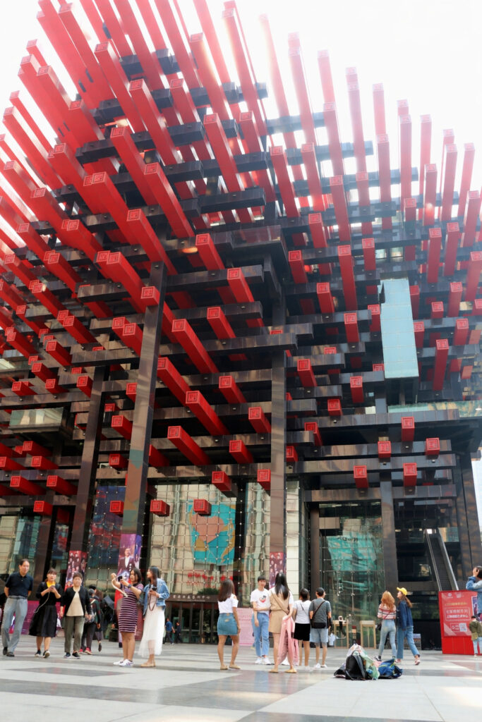 Visitors at Chongqing Art Gallery plaza with red beam architecture and public square