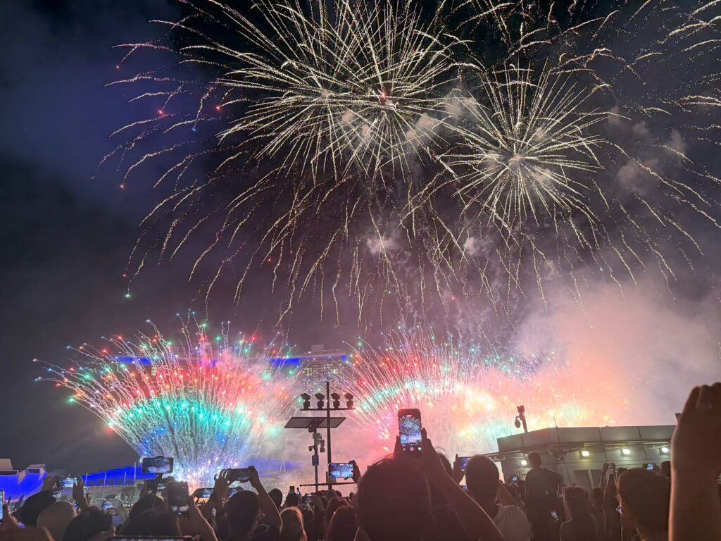 Disney Fireworks and Drone Show at Marina Bay Singapore (Family Experience Guide) 8 Spectators filming colorful Disney fireworks over Marina Bay Sands Singapore