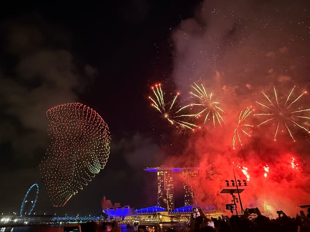 Disney Fireworks and Drone Show at Marina Bay Singapore (Family Experience Guide) 9 Drone formation appearing beside fireworks above Marina Bay Sands during Disney sky show Singapore