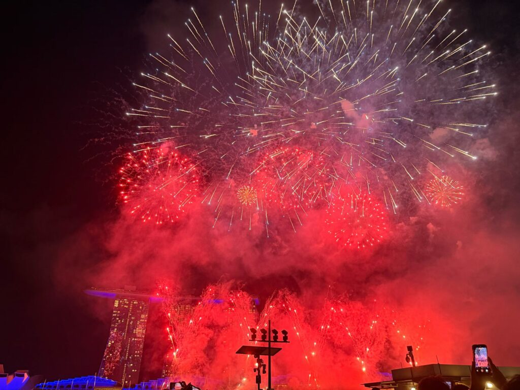 Disney Fireworks and Drone Show at Marina Bay Singapore (Family Experience Guide) 13 Red fireworks filling the sky over Marina Bay Sands during Disney Cruise Line celebration Singapore