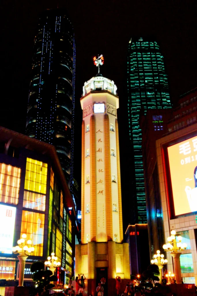 Jiefangbei pedestrian street at night with illuminated monument and skyscrapers in Chongqing city center