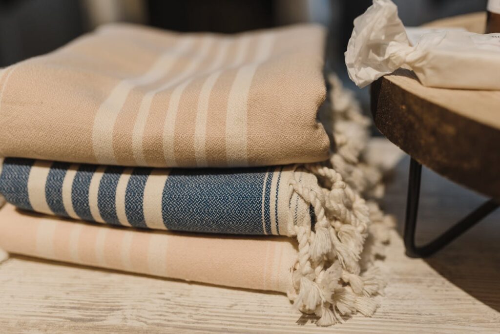 Kids travel blankets folded neatly on a table, showing soft striped fabric and lightweight materials ideal for flights and road trips