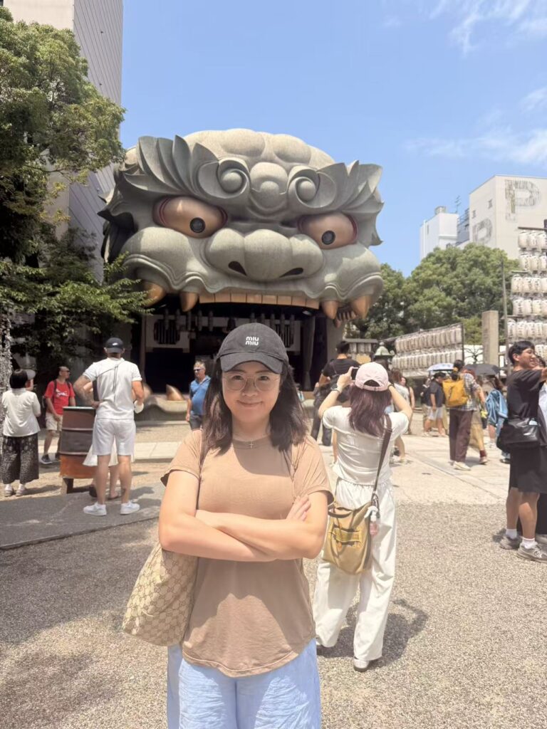 Woman posing in front of the famous lion-head stage at Namba Yasaka Shrine in Osaka, Japan.