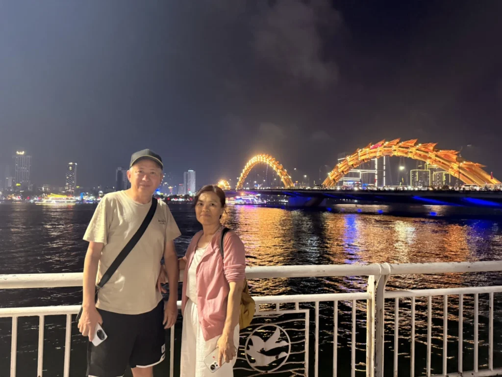 Dragon Bridge Da Nang night view from dragon tail riverside with couple and Han River reflections