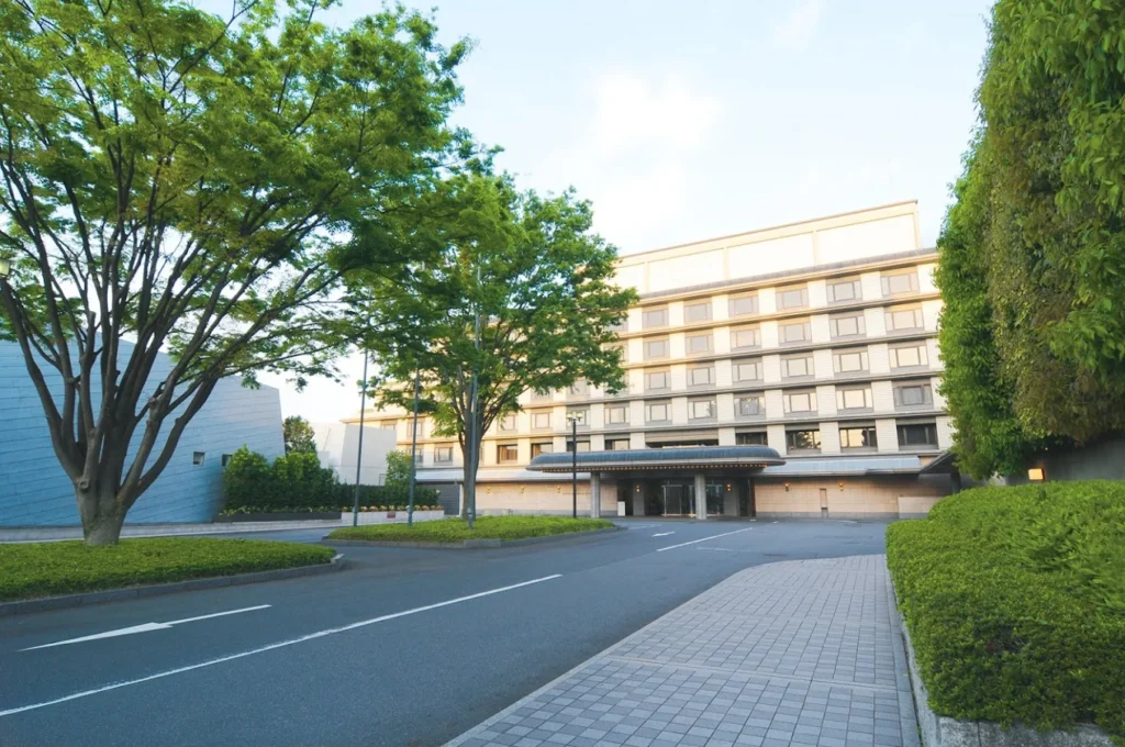 10 Best Muslim-Friendly Hotels (Halal) In Kyoto 9 Kyoto Brighton Hotel exterior surrounded by greenery with spacious driveway and quiet neighborhood setting