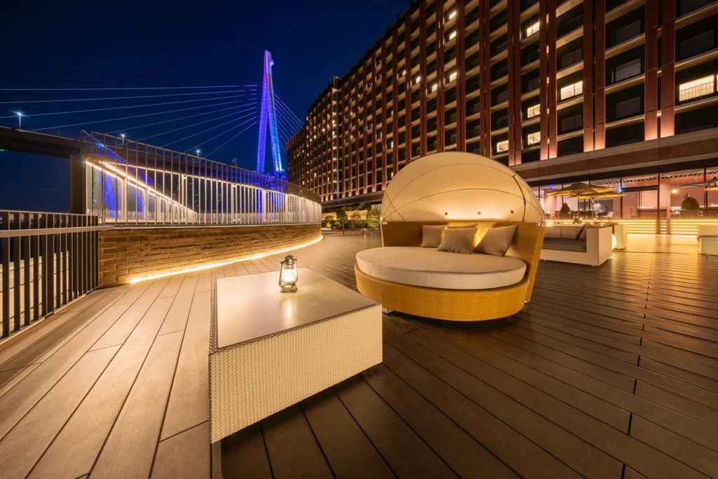 Liber Hotel Osaka outdoor terrace at night with modern seating and city bridge view near Universal Studios Japan