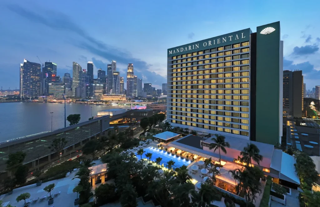 Mandarin Oriental Singapore hotel overlooking Marina Bay skyline with luxury rooms and waterfront views at sunset