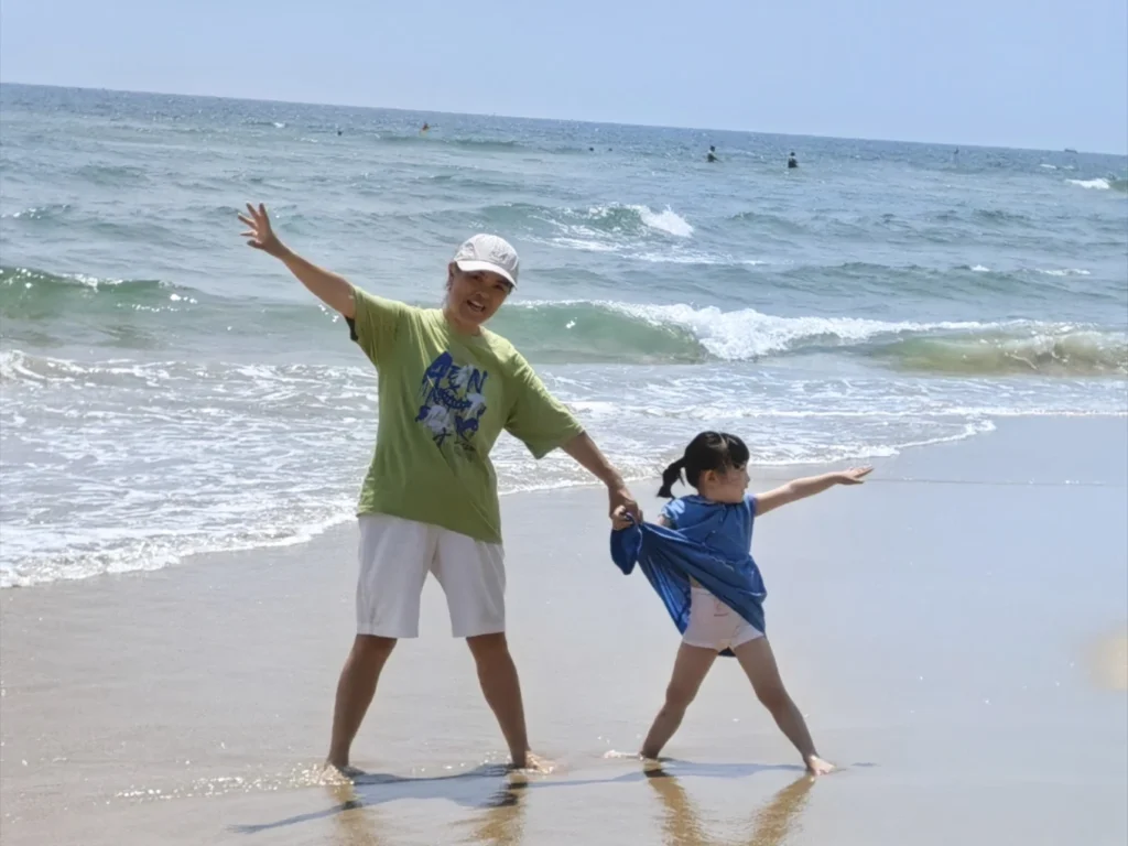 Family enjoying the shoreline at My Khe Beach Da Nang with waves and blue sky