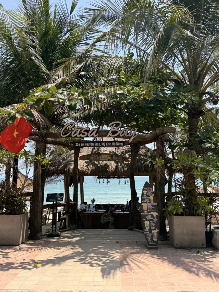 Entrance of Casa Bay beach bar My Khe Beach Da Nang with palm trees and ocean view