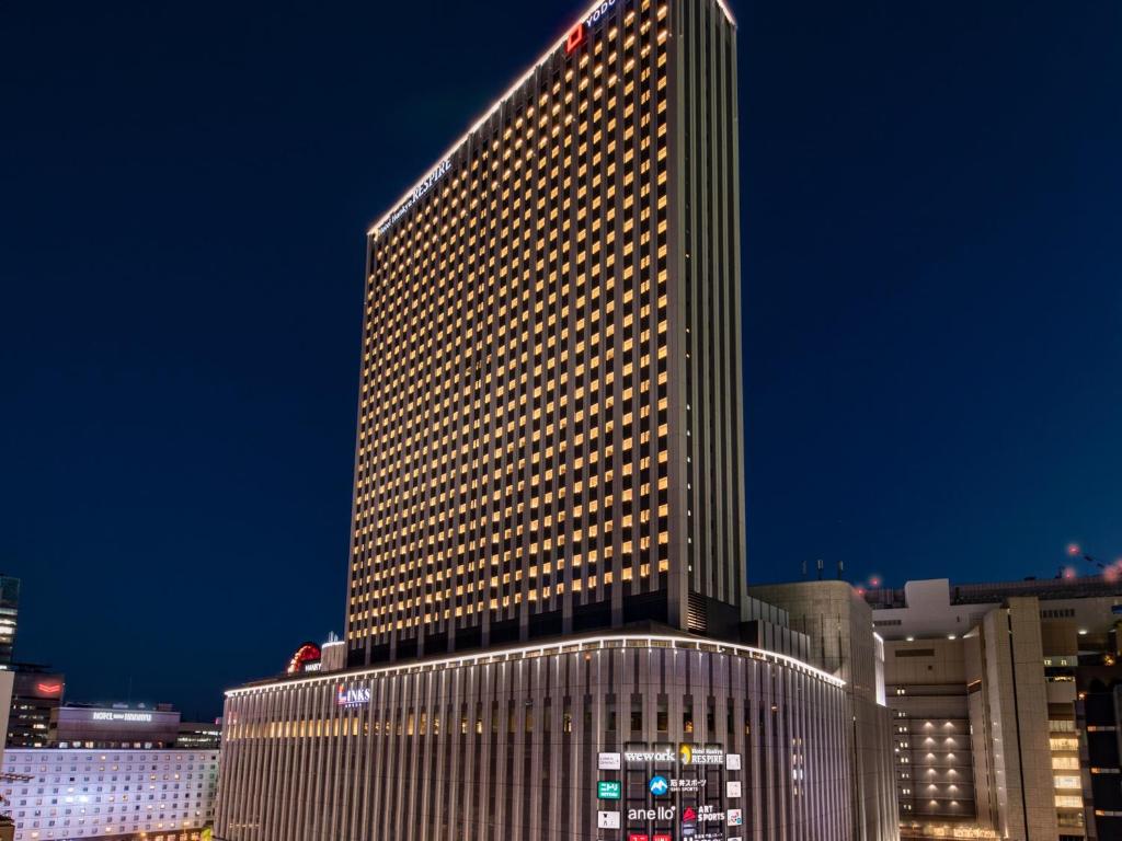 Exterior view of Hotel Hankyu RESPIRE Osaka at night above LINKS Umeda shopping complex in Osaka