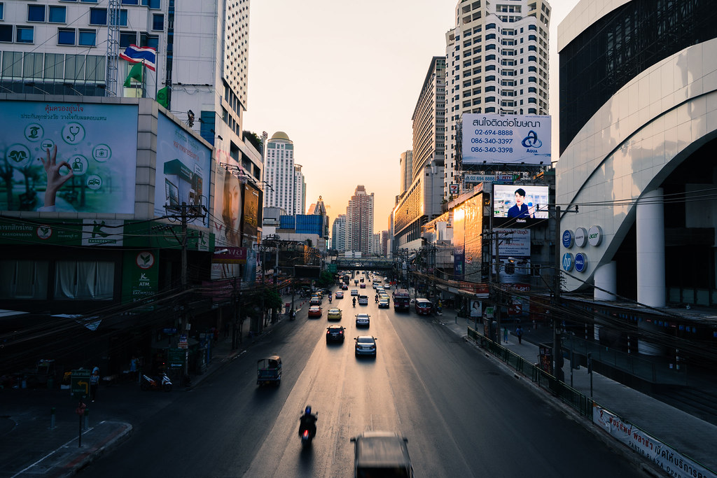 Where to Stay in Bangkok for Muslim Travelers 6 Bangkok Pratunam street view at sunset with traffic and city skyline, a popular area for Muslim travelers staying near halal food and shopping