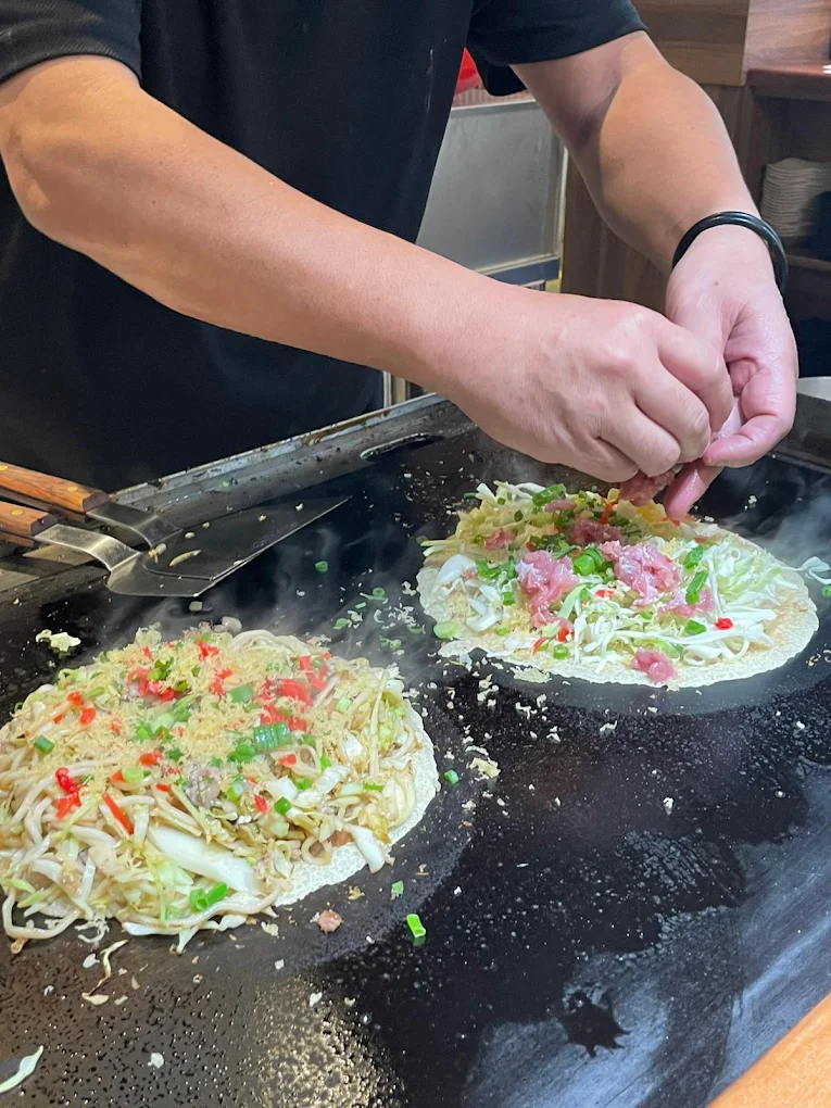 TEPPANIZAKAYA HIDEKI Da Nang Review: Authentic Osaka Teppanyaki Worth Trying 10 Chef preparing okonomiyaki on teppan grill at TEPPANIZAKAYA HIDEKI Da Nang