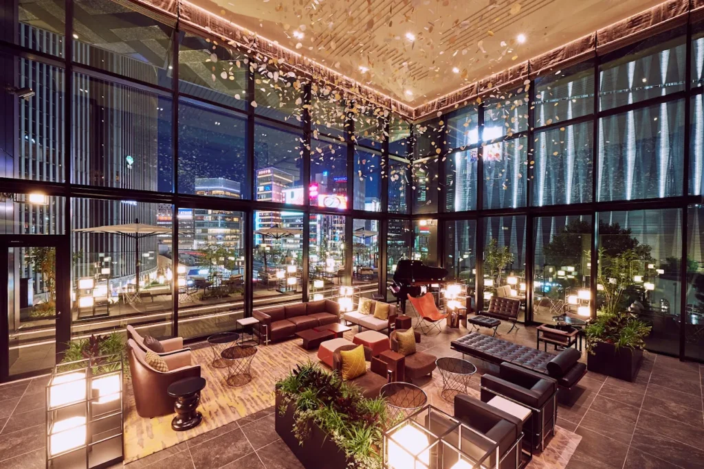 6 Best Boutique Hotels in Ginza Tokyo: Stylish & Unique Stays Guide 7 The Gate Hotel Tokyo by Hulic lounge with floor-to-ceiling windows, modern seating, and city views in Ginza Tokyo at night