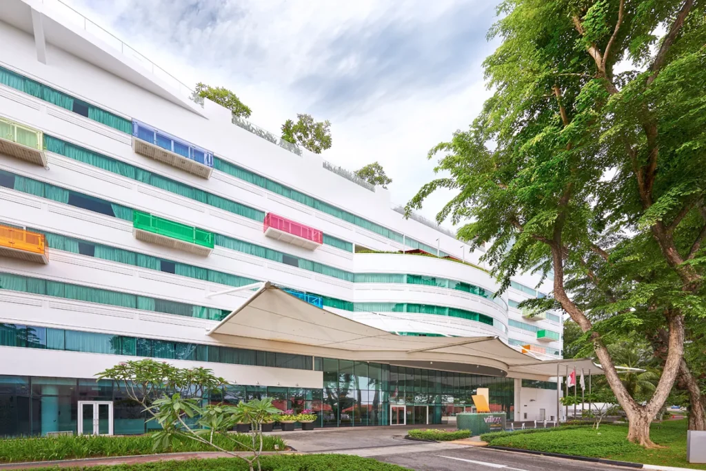 4 Best Hotels Near Changi Airport (Perfect for Layovers & Early Flights) 9 Village Hotel Changi exterior building with colorful balconies and greenery near Changi Airport Singapore